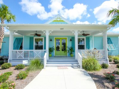 Front view of the Flagler model home with turquoise siding, white trim, and a lime green door.