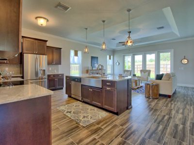 Open-concept kitchen with a large wooden island, granite countertops, and pendant lighting.